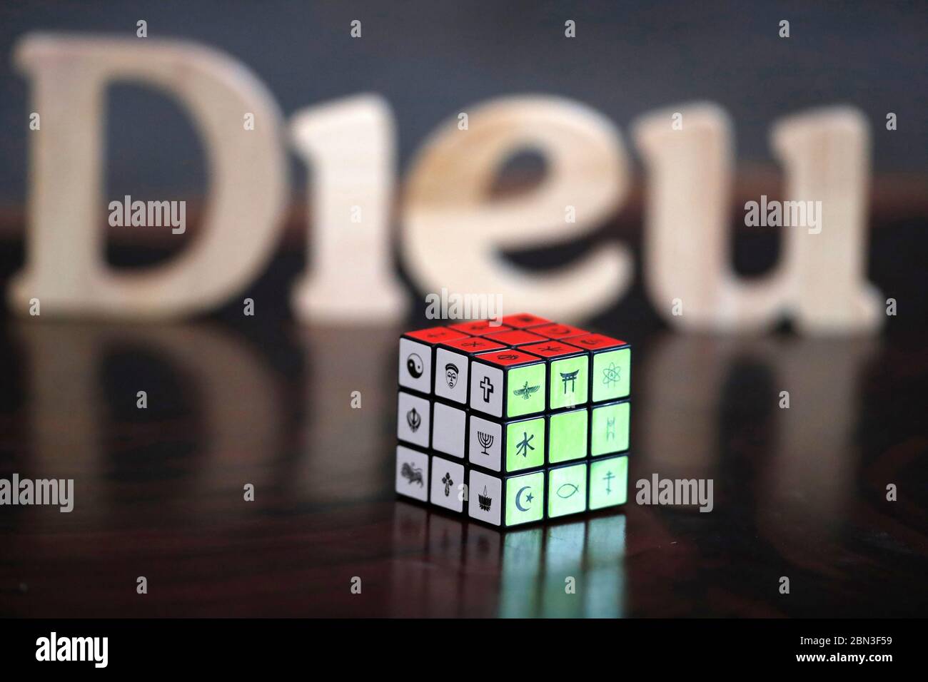 La parola di Dieu ( Dio ) e il cubo di Rubik con simboli religiosi. Concetto di dialogo interreligioso e interreligioso. Simbolo cristiano. Foto Stock