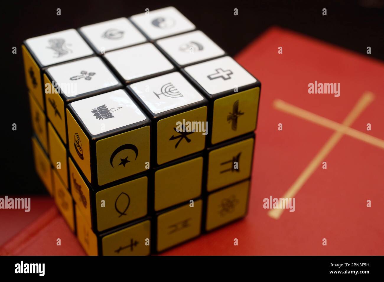 Bibbia e cubo di Rubik con simboli religiosi. Concetto di dialogo interreligioso e interreligioso. Foto Stock