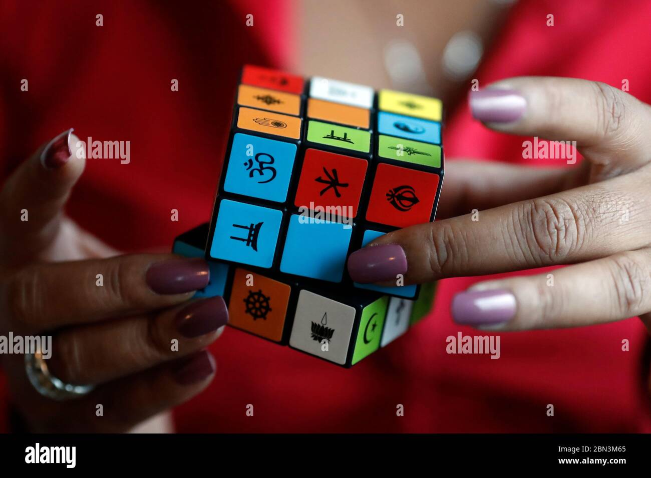 Donna africana con un cubo di Rubik con simboli religiosi. Concetto di dialogo interreligioso e interreligioso. Madagascar. Foto Stock