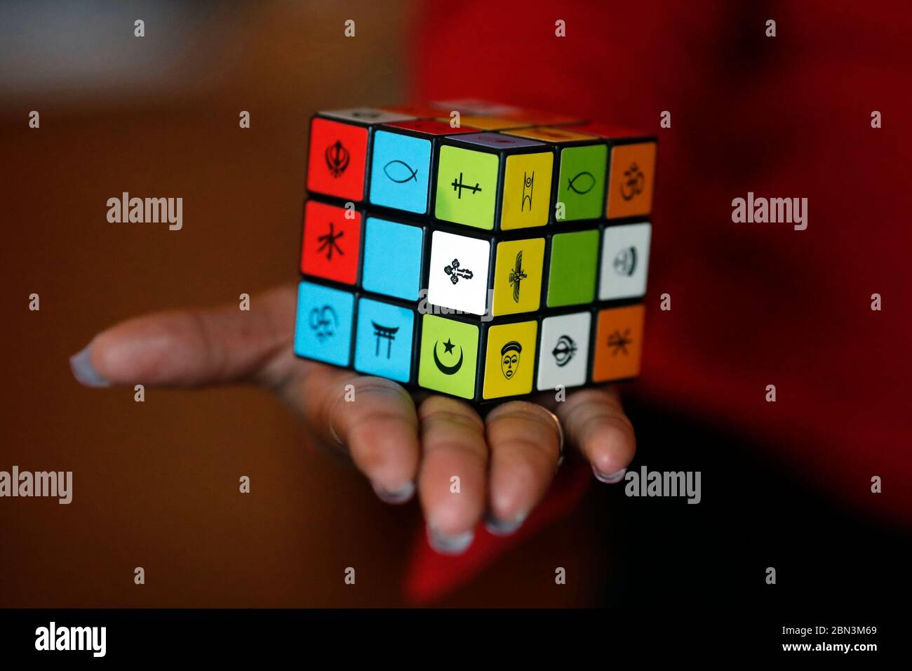 Donna africana con un cubo di Rubik con simboli religiosi. Concetto di dialogo interreligioso e interreligioso. Madagascar. Foto Stock