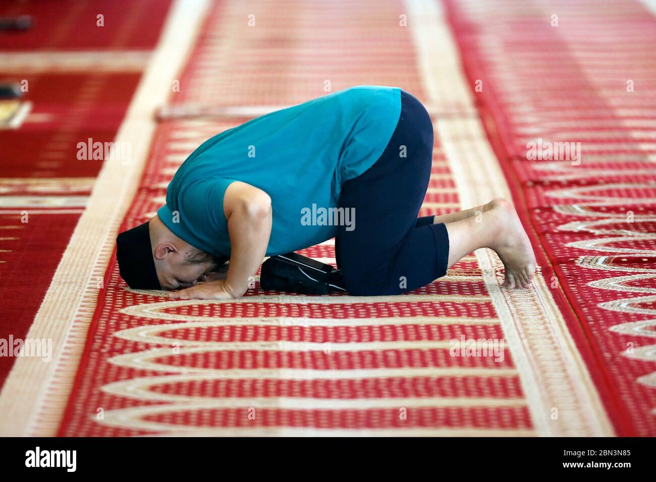 La Moschea Nazionale o Masjid Negara. Sala di preghiera. Uomo musulmano che prega sul tappeto. Kuala Lumpur. Malesia. Foto Stock
