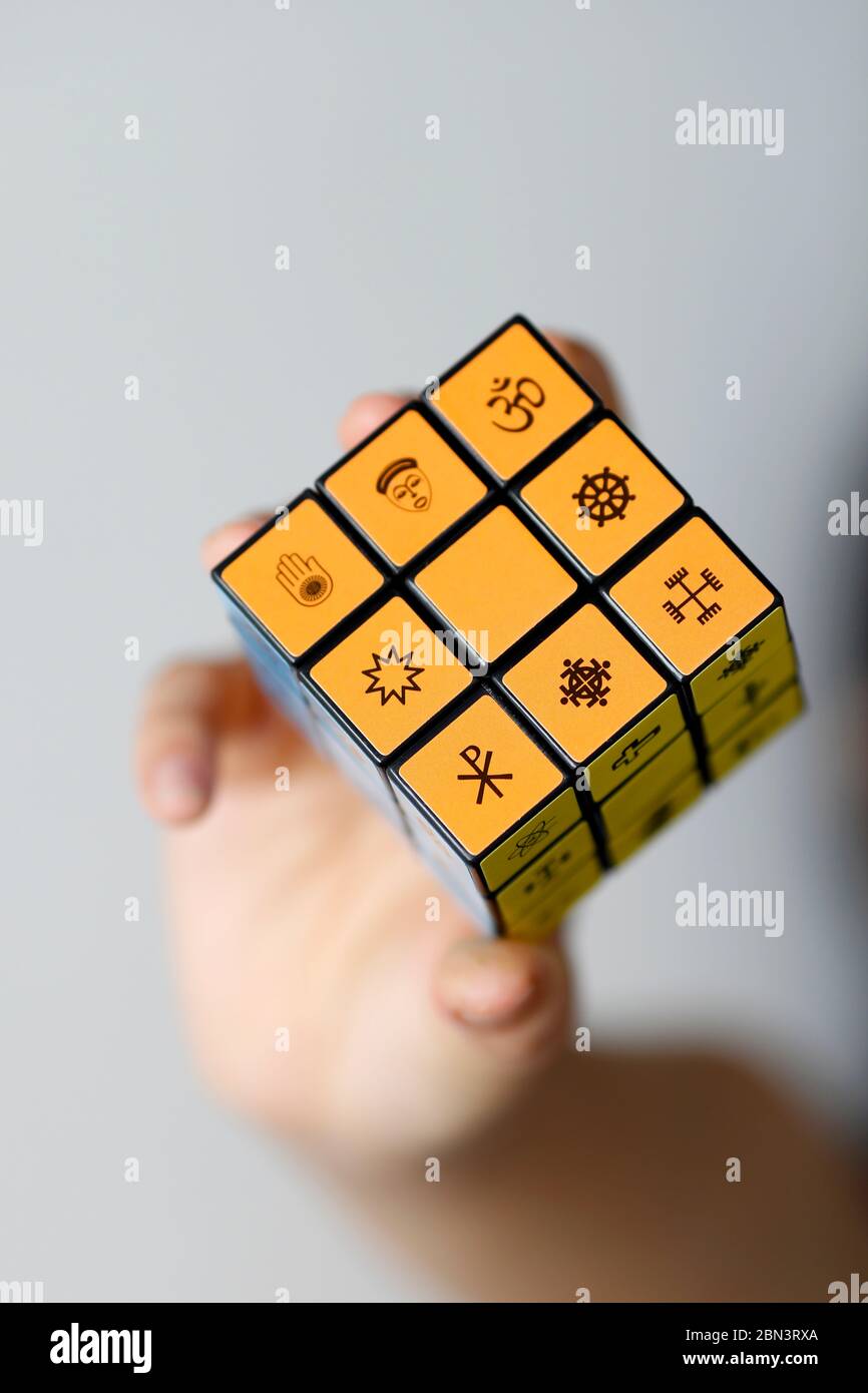 Donna con il cubo di Rubik con simboli religiosi. Concetto di dialogo interreligioso e interreligioso. Foto Stock