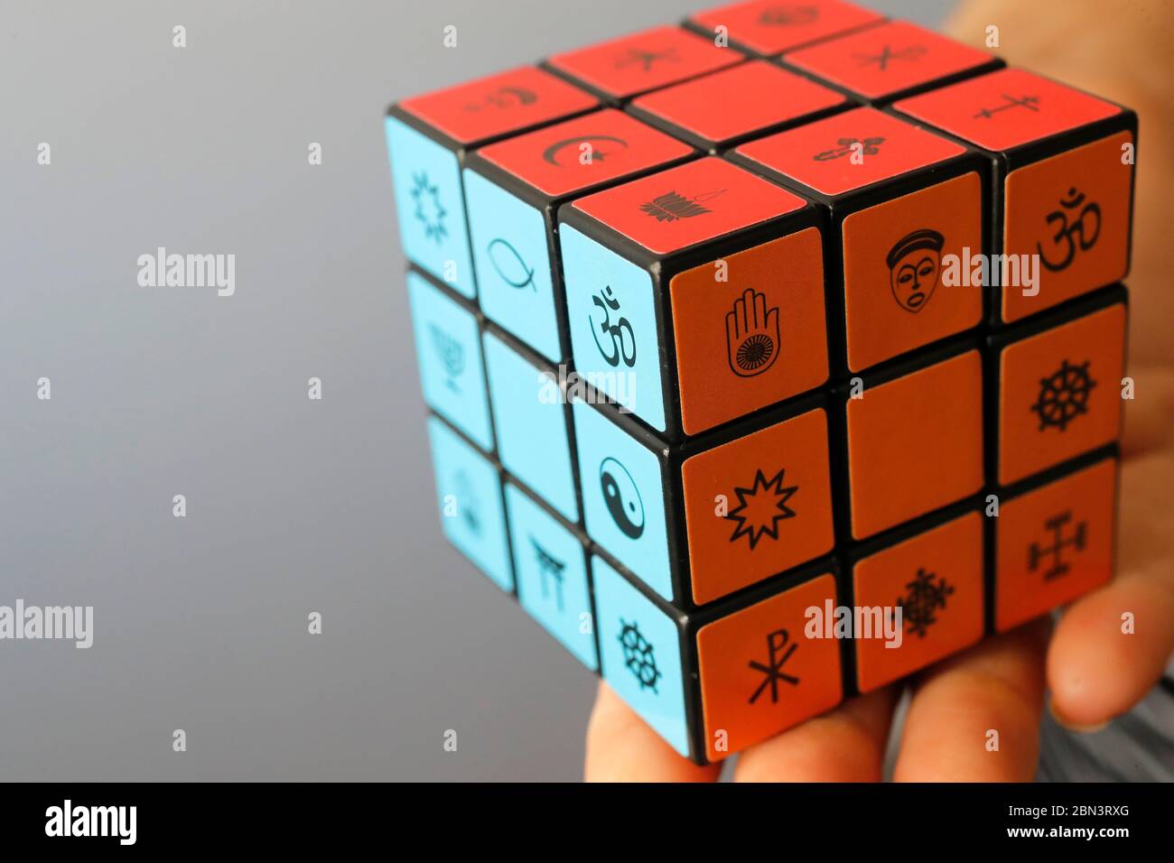 Donna con il cubo di Rubik con simboli religiosi. Concetto di dialogo interreligioso e interreligioso. Foto Stock