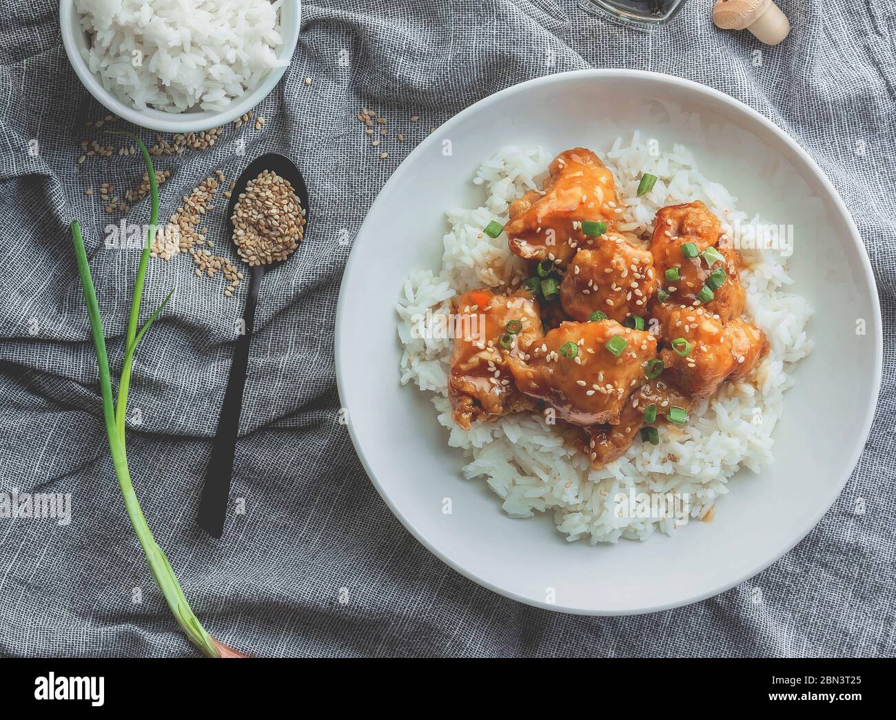 Delizioso pollo con salsa d'arancia dolce e acora accompagnata da riso jasmine ricetta in stile cinese, vista dall'alto. Foto Stock