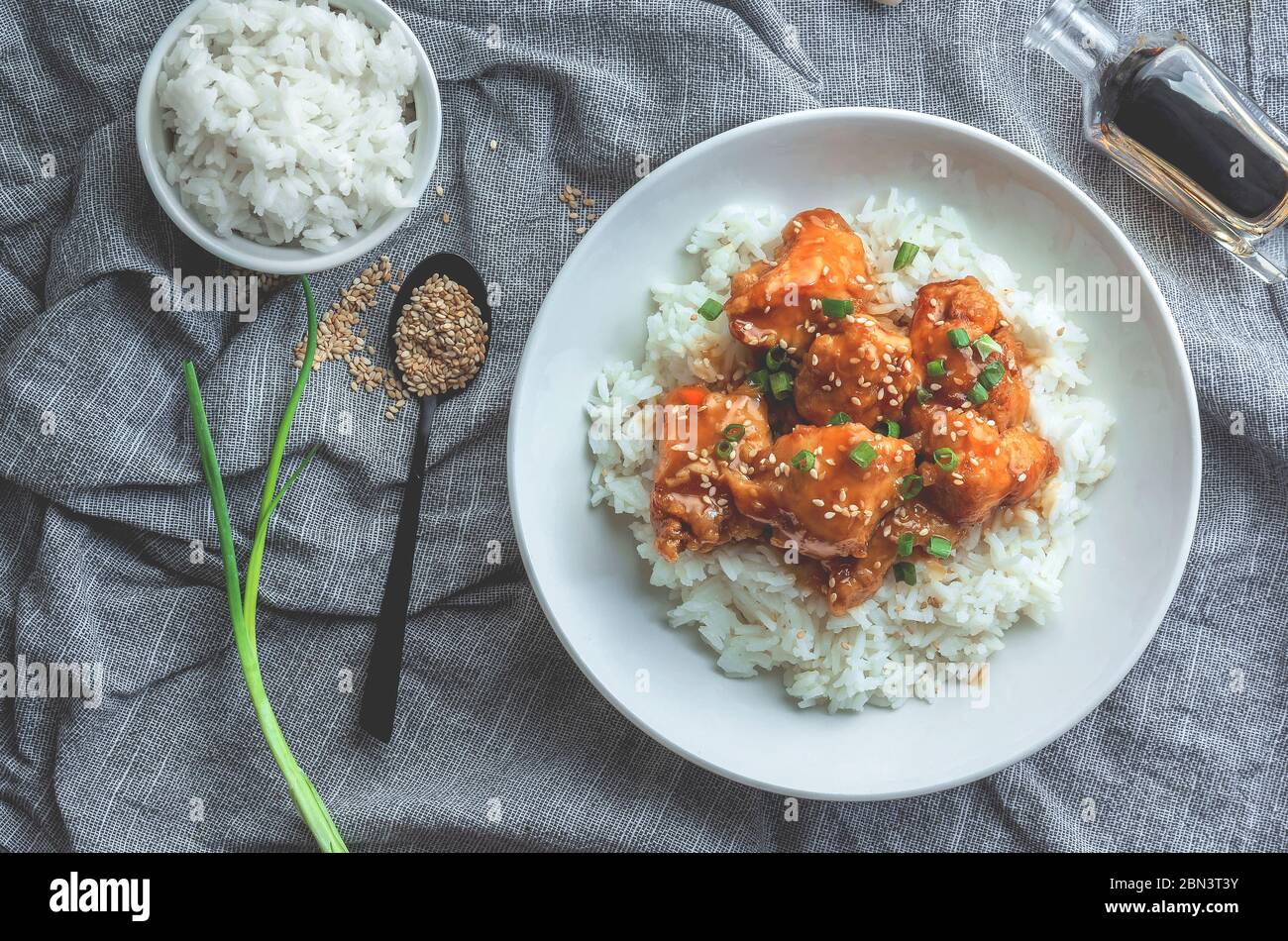 Delizioso pollo con salsa d'arancia dolce e acora accompagnata da riso jasmine ricetta in stile cinese, vista dall'alto. Foto Stock