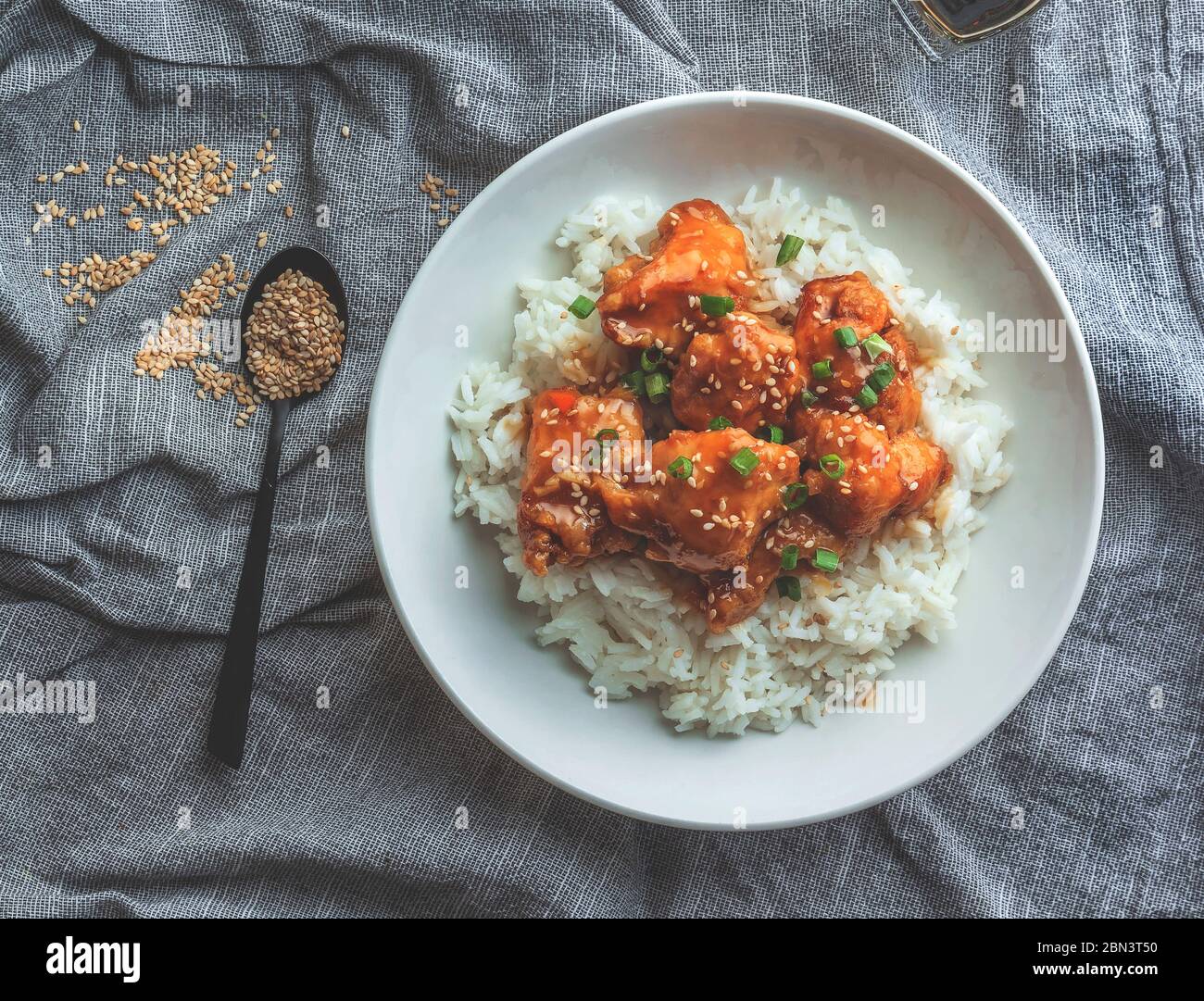 Delizioso pollo con salsa d'arancia dolce e acora accompagnata da riso jasmine ricetta in stile cinese, vista dall'alto. Foto Stock