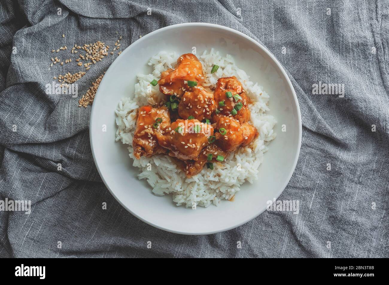 Delizioso pollo con salsa d'arancia dolce e acora accompagnata da riso jasmine ricetta in stile cinese, vista dall'alto. Foto Stock