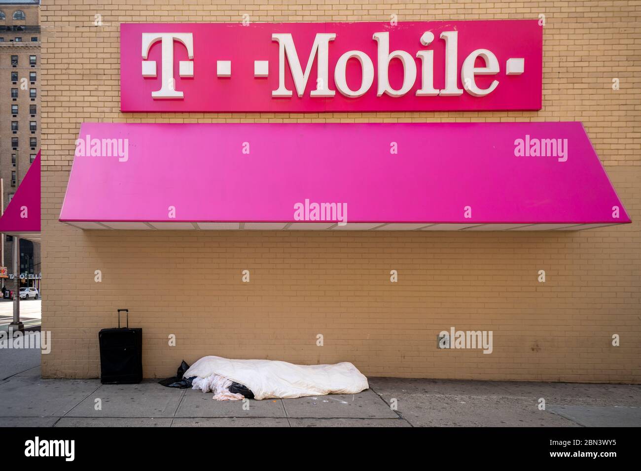Senzatetto individuale dorme accanto a un negozio T-Mobile a Midtown Manhattan a New York il sabato 2 maggio 2020. (© Richard B. Levine) Foto Stock