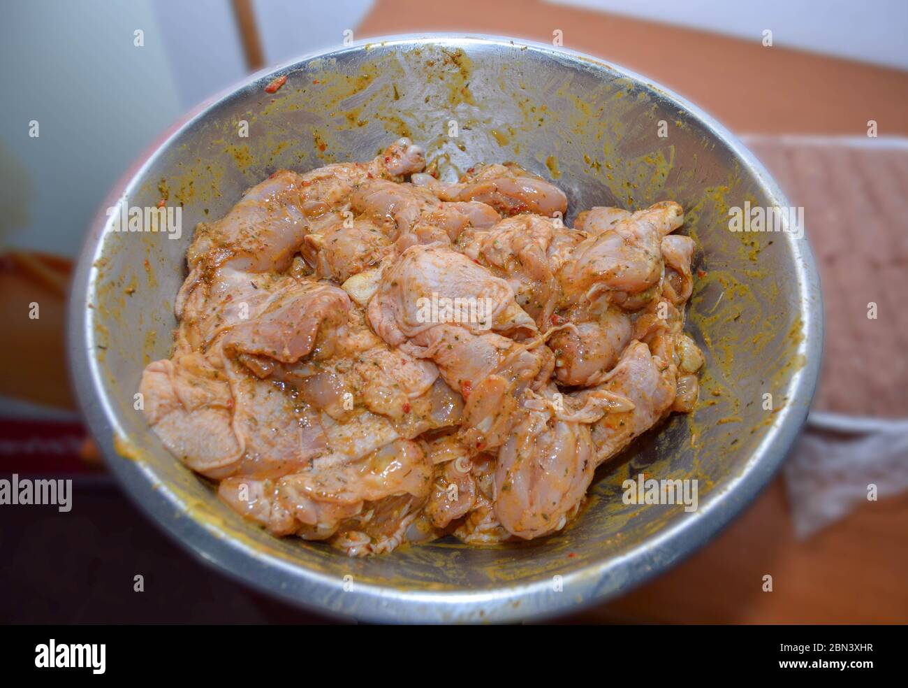 Ali di pollo appena condite preparate in una ciotola di metallo, pronte per essere cucinate e gustato come un piatto gustoso e sano, condimenti su carne di pollo cruda essere Foto Stock