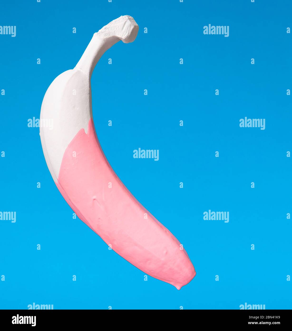 Concetto di arte creativa. Vernice rosa gocciolante da banana bianca Foto Stock