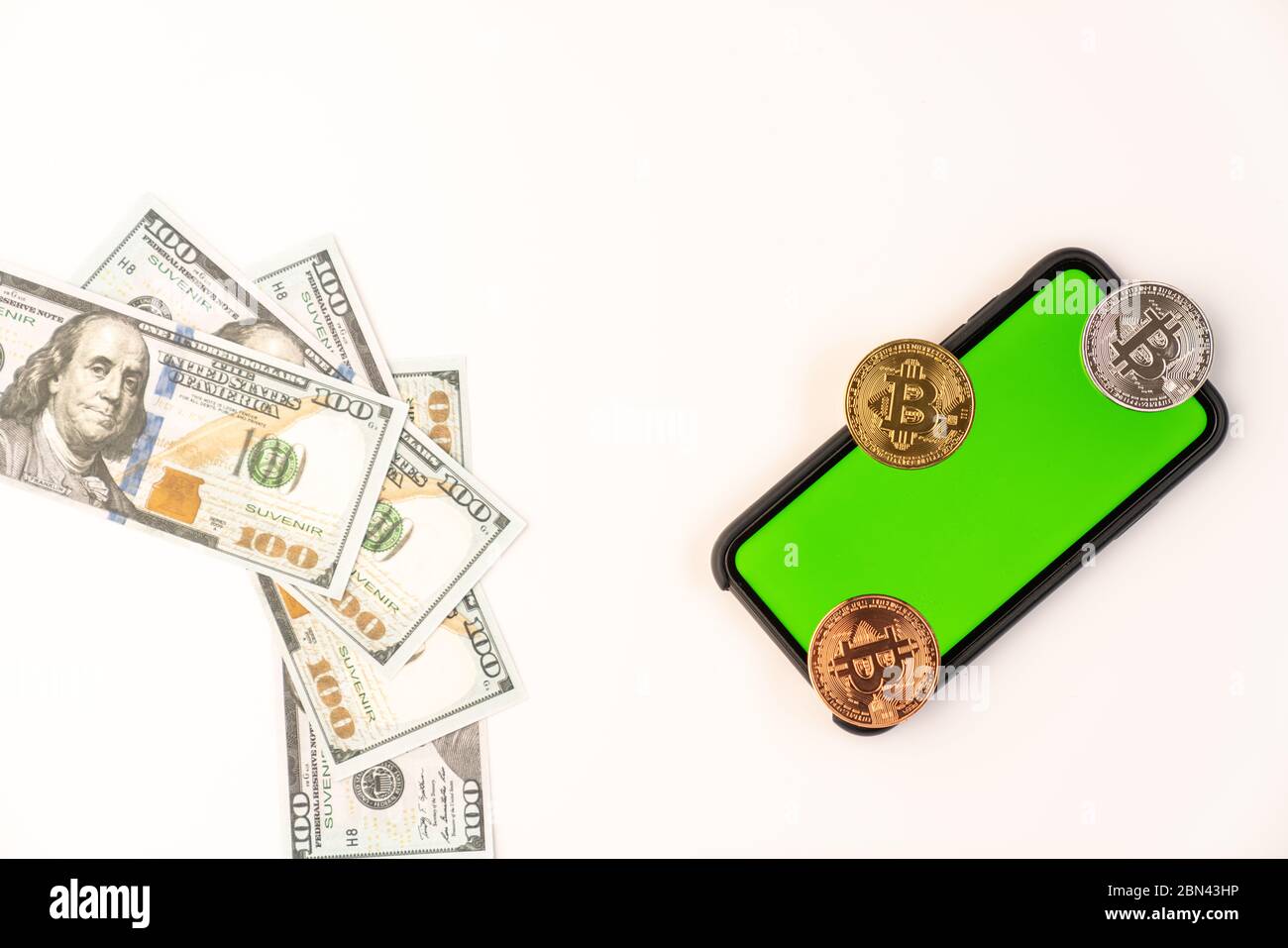 Bollette in dollari USA e monete in bitcoin su uno smartphone con schermo verde isolato su sfondo bianco Foto Stock