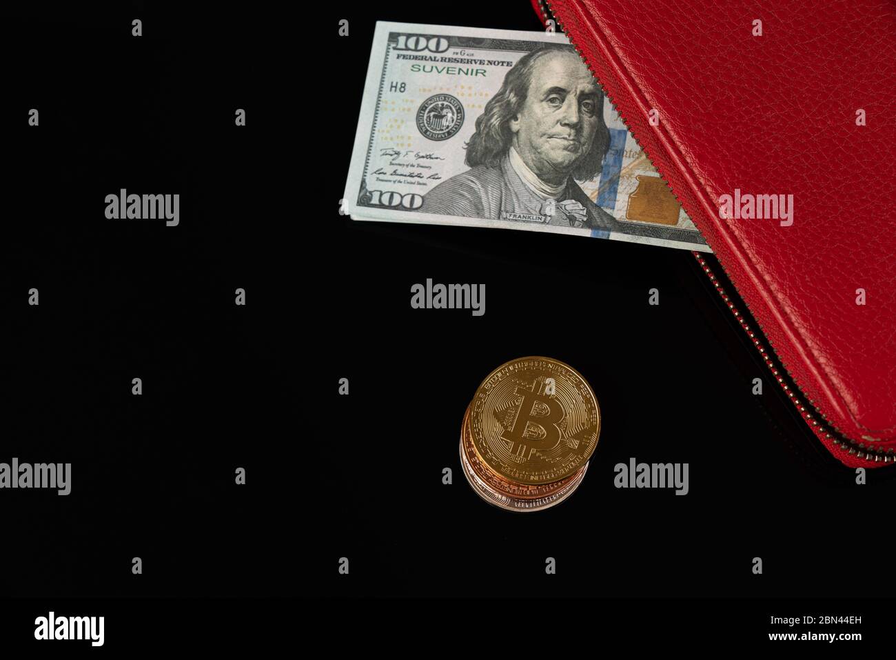 Banconote in dollari in portafoglio rosso e monete in moneta di bitcoin isolate su sfondo nero Foto Stock