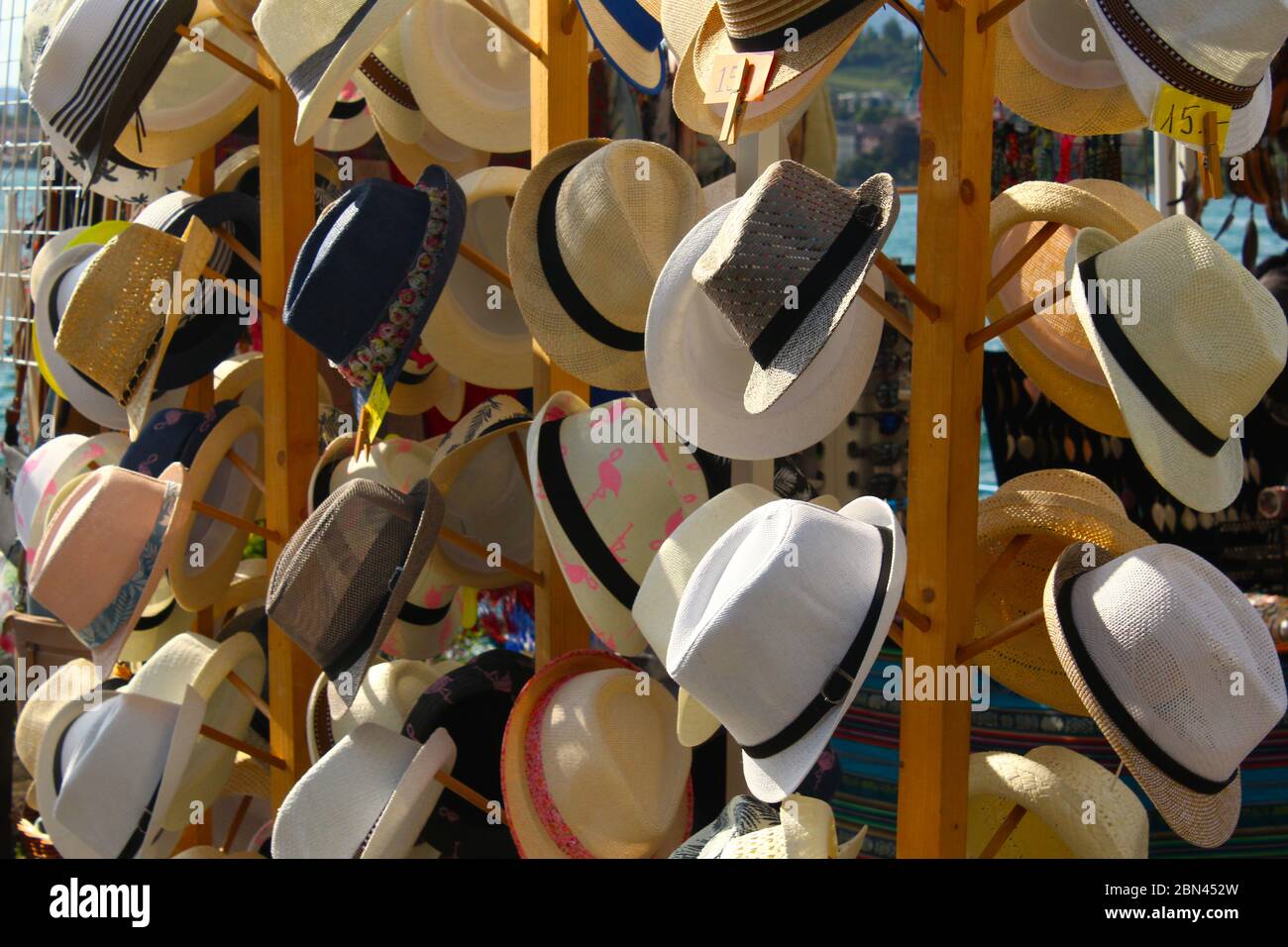 Cappelli di paglia in vendita al mercato di strada in un pomeriggio soleggiato vicino a un lago Foto Stock