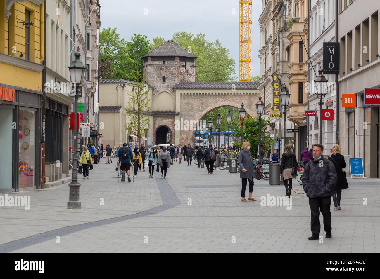 Vista lungo Sendlinger Straße (zona pedonale) verso Sendlinger Tor (porta storica della città). Include persone e molti negozi e negozi. Formato panorama Foto Stock