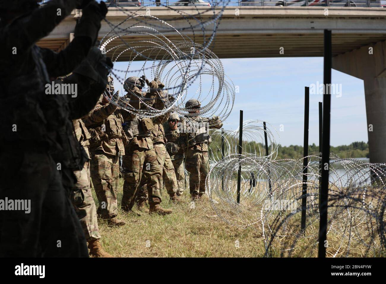 Soldati con l'operazione Faithful Patriot dispiegano filo di concertina in una posizione lungo il confine sud-occidentale degli Stati Uniti vicino Hidalgo, Texas. L'esercito degli Stati Uniti Nord è schierato al confine sud-occidentale a sostegno dell'operazione Faithful Patriot sotto l'autorità del comando degli Stati Uniti del Nord per sostenere il Dipartimento di sicurezza interna e la missione della Dogana e della protezione delle frontiere per assicurare il confine. 2 novembre 2018. Foto Stock