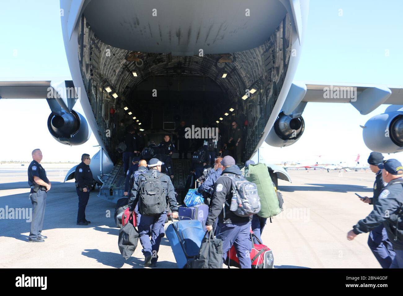 Stati Uniti Delle dogane e della protezione delle frontiere degli ufficiali dalla El Paso ufficio da campo a bordo di un U.S. Air Force C-17 aeromobili all'Aeroporto Internazionale di El Paso per il trasporto in California nel supporto di CBP il funzionamento della linea sicura. Il CBP si muove centinaia di personale supplementare in posizione in modo da garantire la possibilità di affrontare in modo sicuro più potenziali sopravvenienze, a e tra il Southern California porti di entrata. Novembre 15, 2018. Il CBP Foto Stock