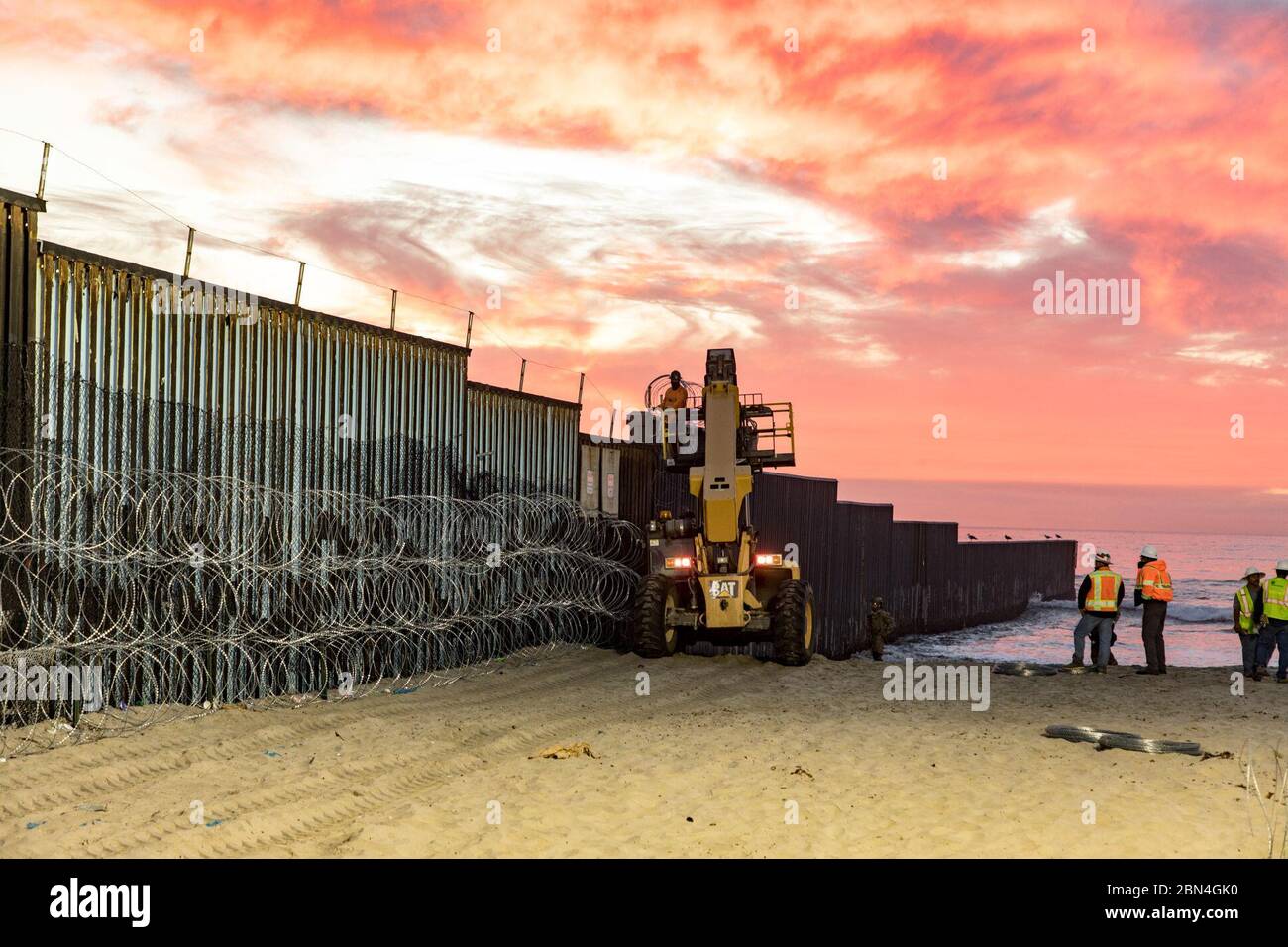 Gli agenti della pattuglia di frontiera degli Stati Uniti monitorano le attività al Border Field State Park di Imperial Beach, California, dove il personale stava rinforzando il muro di confine con filo a fisarmonica. L'operazione fa parte degli sforzi in corso per proteggere il confine meridionale degli Stati Uniti e proteggere il pubblico. Foto Stock