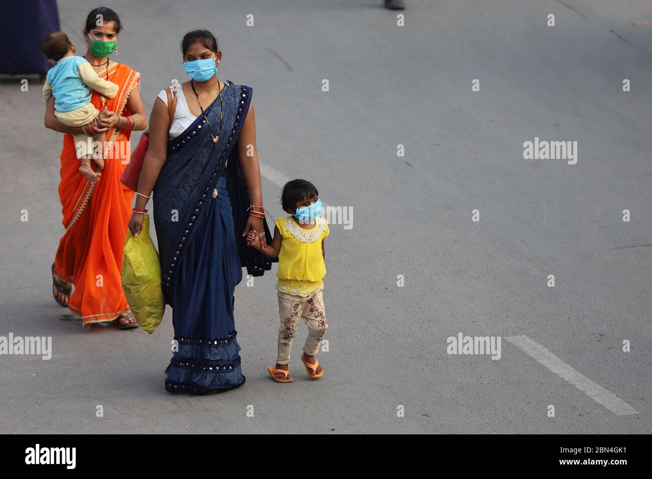 Le donne con i loro bambini si sono recate alla stazione ferroviaria per salire a bordo dei treni di ritorno ai loro stati d'origine durante il covid 19 pandemic.India annuncia una riapertura limitata della sua rete ferroviaria gigante dopo un blocco di quasi sette settimane per rallentare la diffusione della malattia di coronavirus (COVID-19). Foto Stock