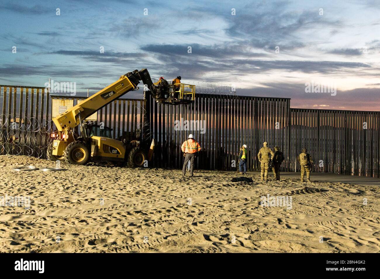 Gli agenti della pattuglia di confine degli Stati Uniti presso il Border Field State Park di Imperial Beach, California, sorvegliano il personale che rinforza il muro di confine degli Stati Uniti con filo a fisarmonica. La pattuglia di frontiera continua a garantire la sicurezza del pubblico e a proteggere il confine meridionale degli Stati Uniti. Foto Stock