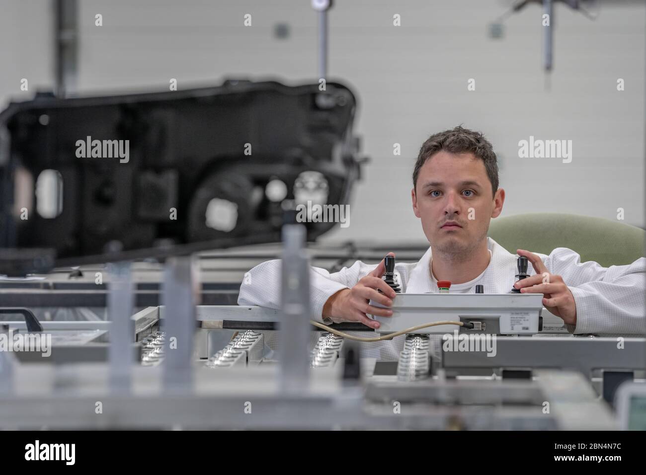 Il tecnico di qualità esegue misurazioni 3D di parti in plastica pressofuse con l'aiuto di un robot per l'industria automobilistica Foto Stock
