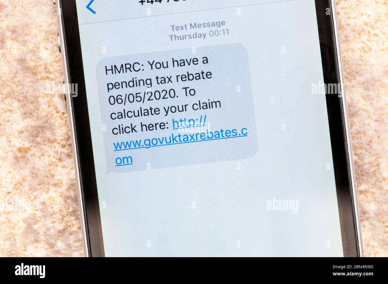 Un messaggio di truffa visualizzato su un iphone che finge di provenire da HMRC con un rimborso fiscale in sospeso. Foto Stock