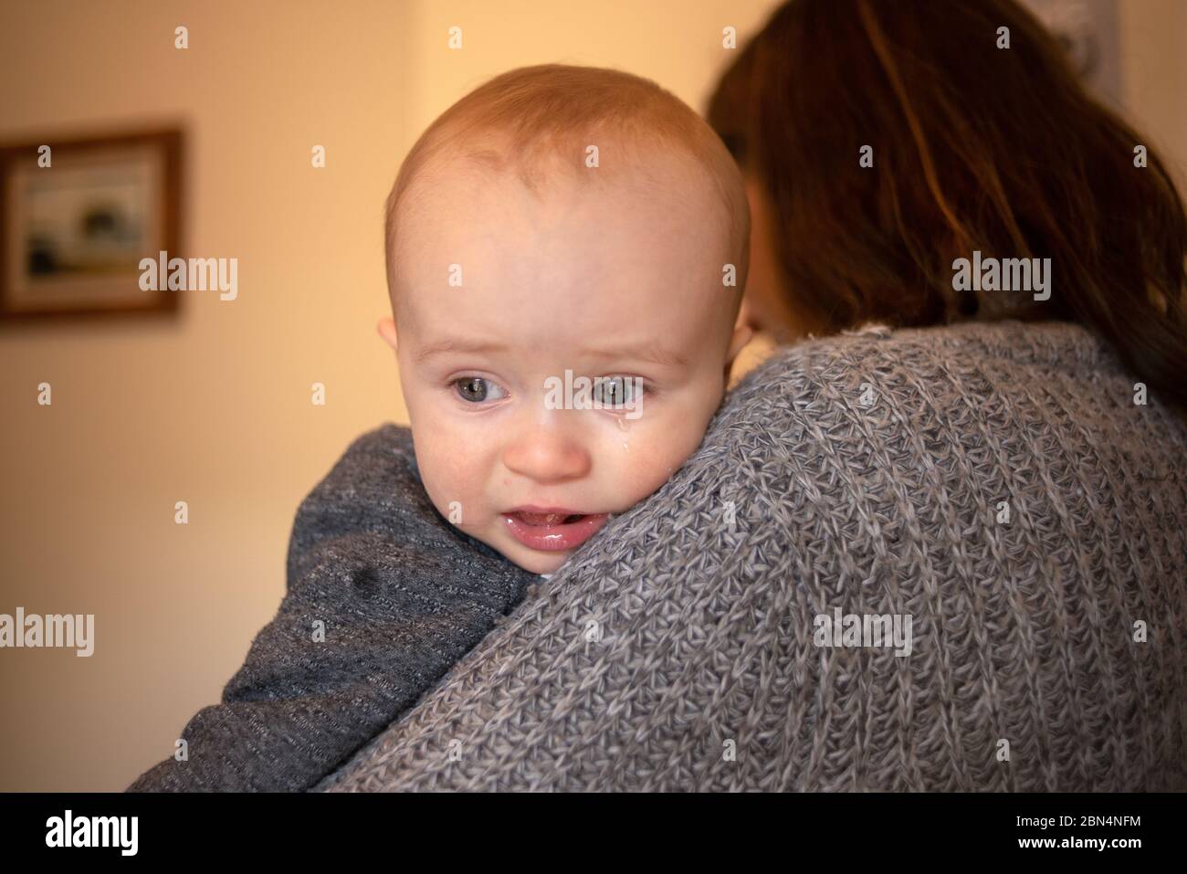 Un bambino di 11 mesi con la madre sconvolto. Foto Stock