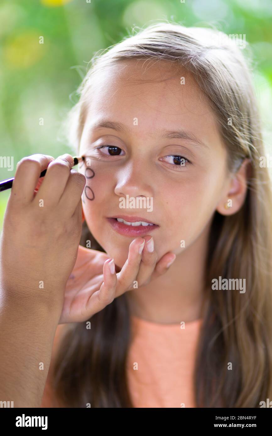 Bella Teen ottenere il suo viso dipinto, Makeup, all'aperto Foto Stock