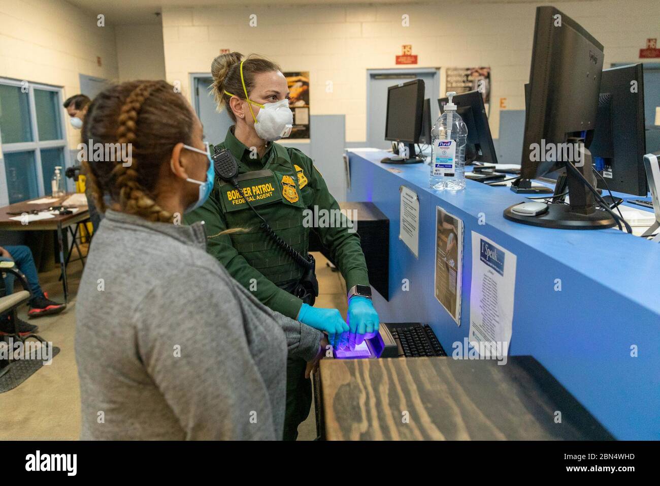 Gli agenti della pattuglia di frontiera degli Stati Uniti presso la Brown Field Station in California utilizzano dispositivi di protezione individuale (DPI) e seguono protocolli di distanziamento sociale per proteggere se stessi e gli individui dalla COVID-19. Queste precauzioni sono state implementate nell'ambito degli sforzi federali per garantire la sicurezza durante la pandemia. Foto Stock