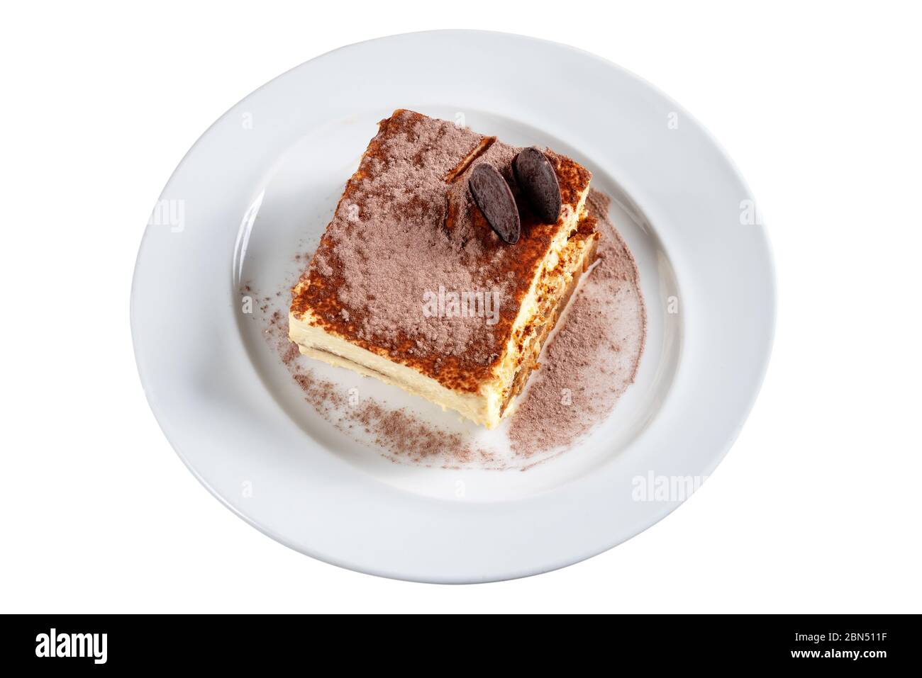 Tiramisù al cioccolato al cacao, torta decorata con biscotti su un piatto bianco. Primo piano. Su sfondo bianco. Foto Stock