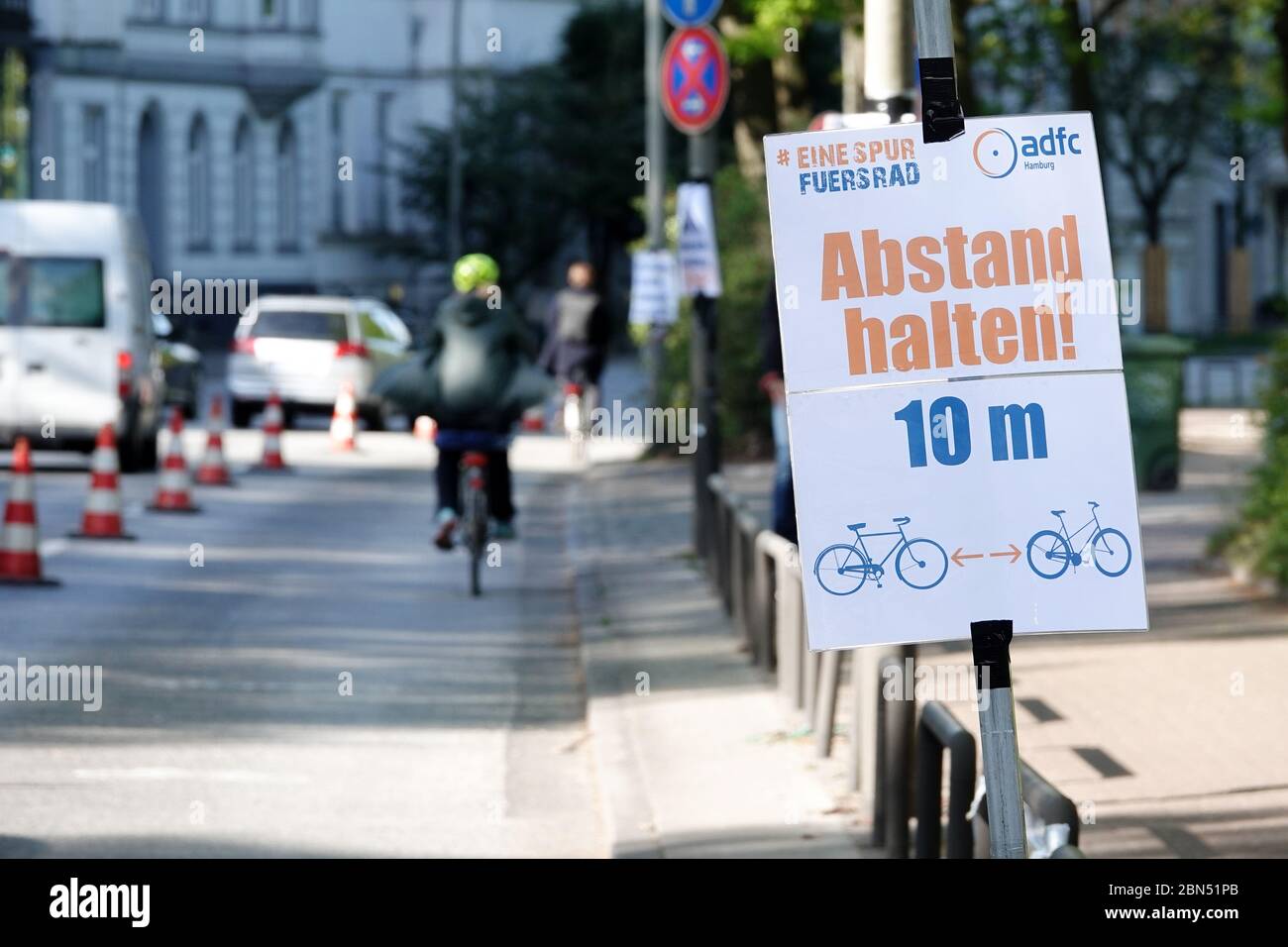 Amburgo, Germania. 04 maggio 2020. Un cartello con l'iscrizione 'mantenere una distanza di 10 m' si trova accanto ad una corsia temporaneamente chiusa sull'Alster, che è stata dichiarata pista ciclabile. L'Allgemeine Deutsche Fahrad-Club (ADFC) ha aperto la prima pista ciclabile a comparsa ad Amburgo. Per due giorni, il club ciclistico ha bloccato una corsia della strada a più corsie sull'Alster tra l'Hotel Atlantic e il ponte Schwanenwikbrücke in modo che possa essere utilizzato dai ciclisti. Credit: Bodo Marks/dpa/Alamy Live News Foto Stock