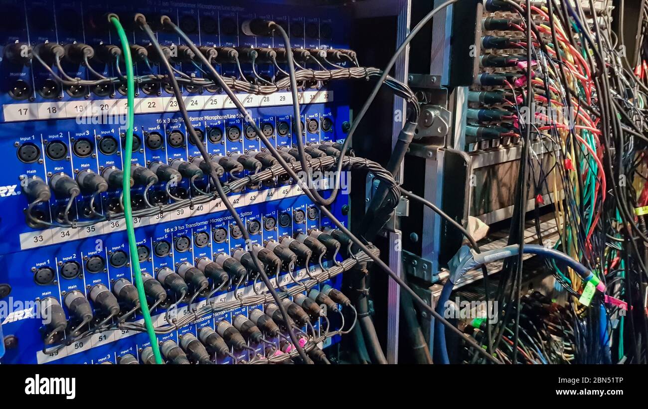 Una scheda con molti connettori femmina e fili collegati. Installazione audio. Attrezzatura per tecnici del suono Foto Stock