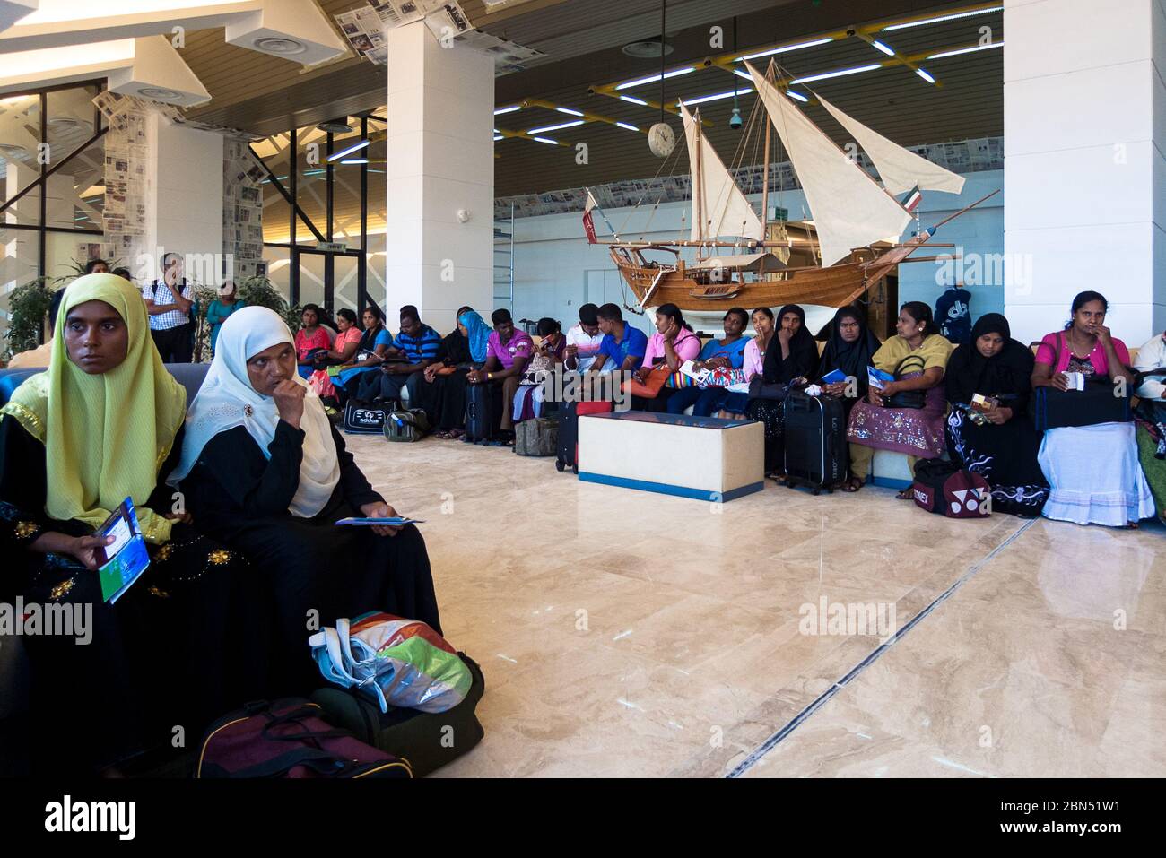 Kuwait City, Kuwait: Gruppo di indiani nella sala d'attesa dell'aeroporto di Kuwait City che attende di partire per l'India Foto Stock