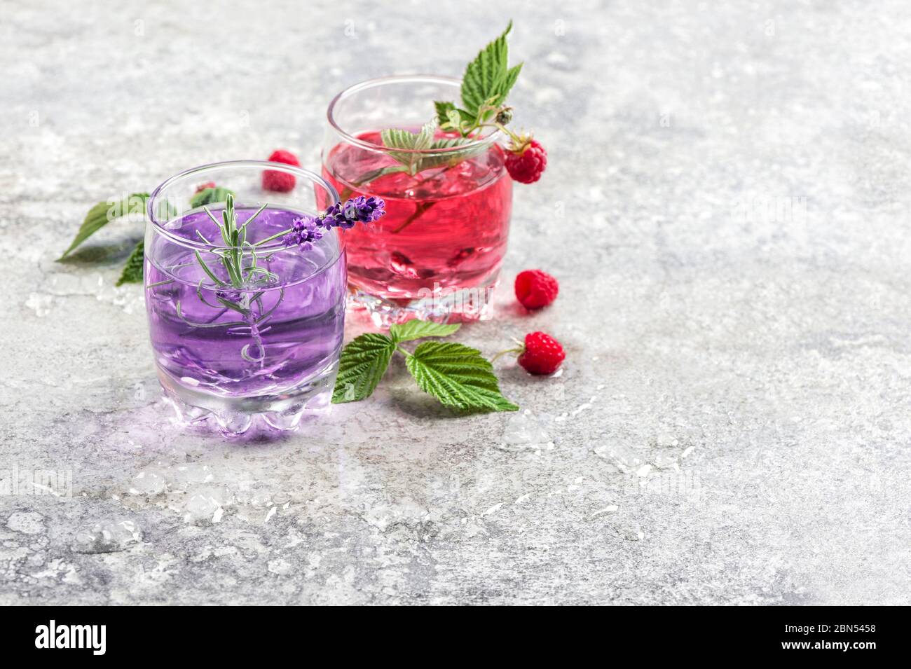 Bere con lamponi, fiori di lavanda e ghiaccio. Limonata estiva fredda Foto Stock