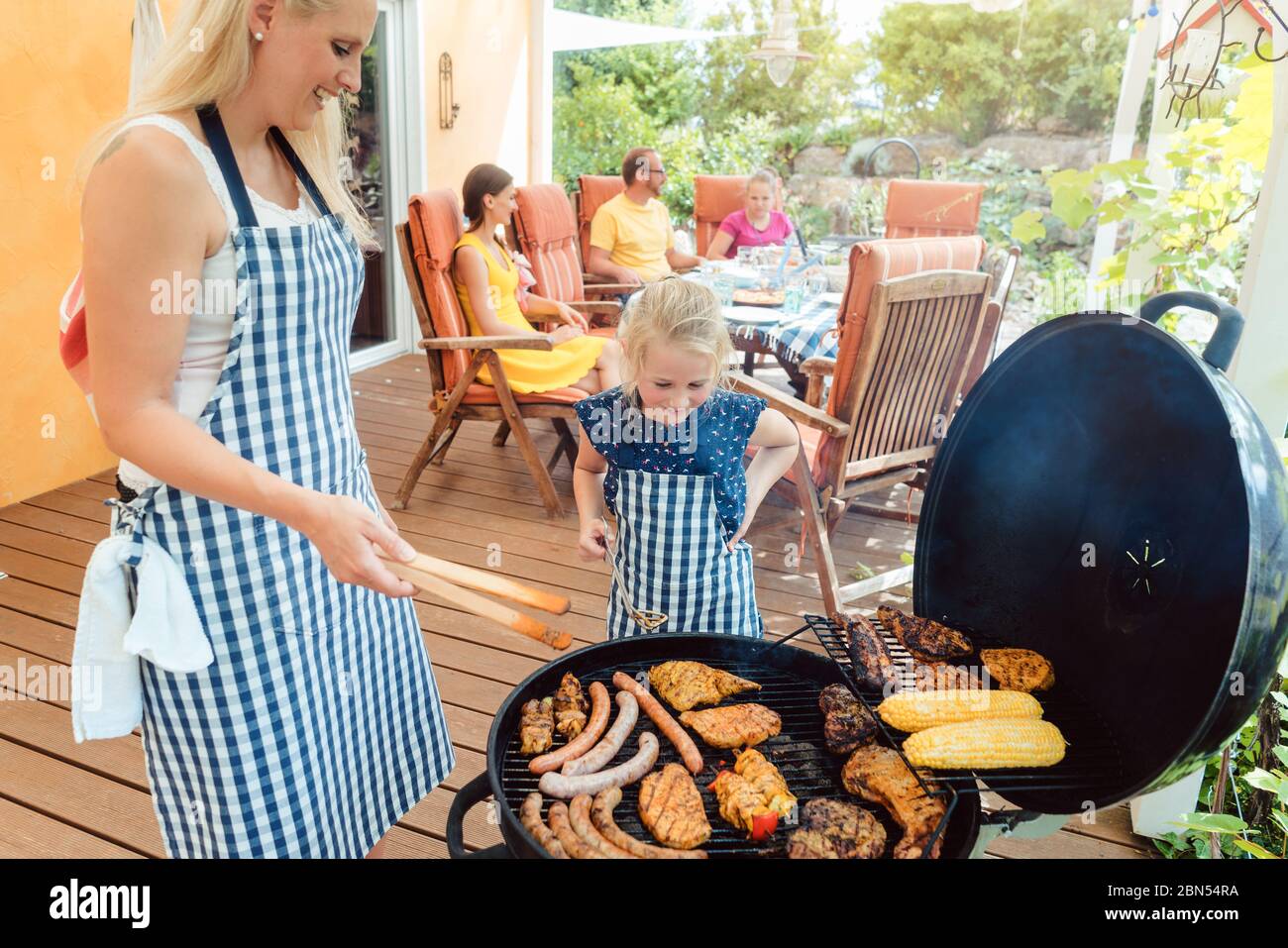 Barbecue party in giardino con mamma e figlia al grill Foto Stock