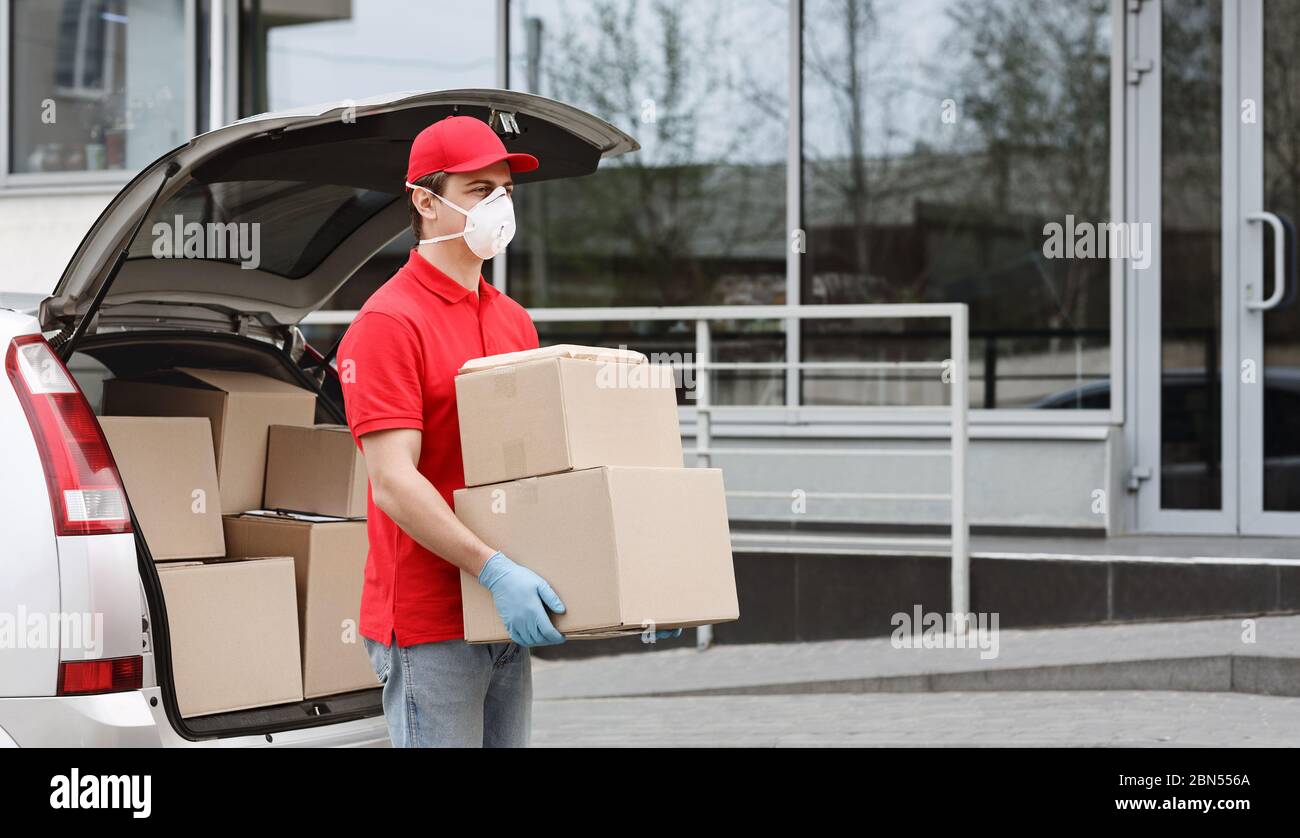 Isolamento automatico del cliente e concetto di consegna rapida. Il corriere toglie i pacchi dell'auto. Foto Stock