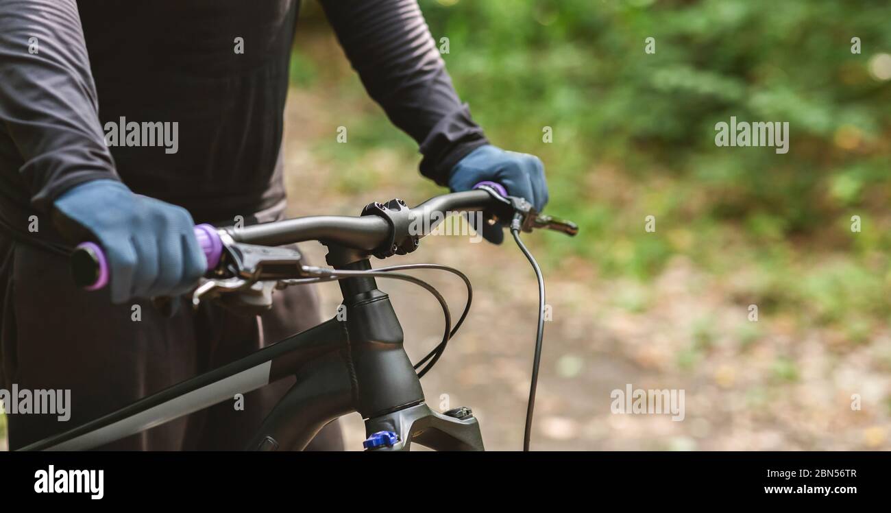 Immagine ritagliata di sport bike manubrio su sfondo di foresta Foto Stock