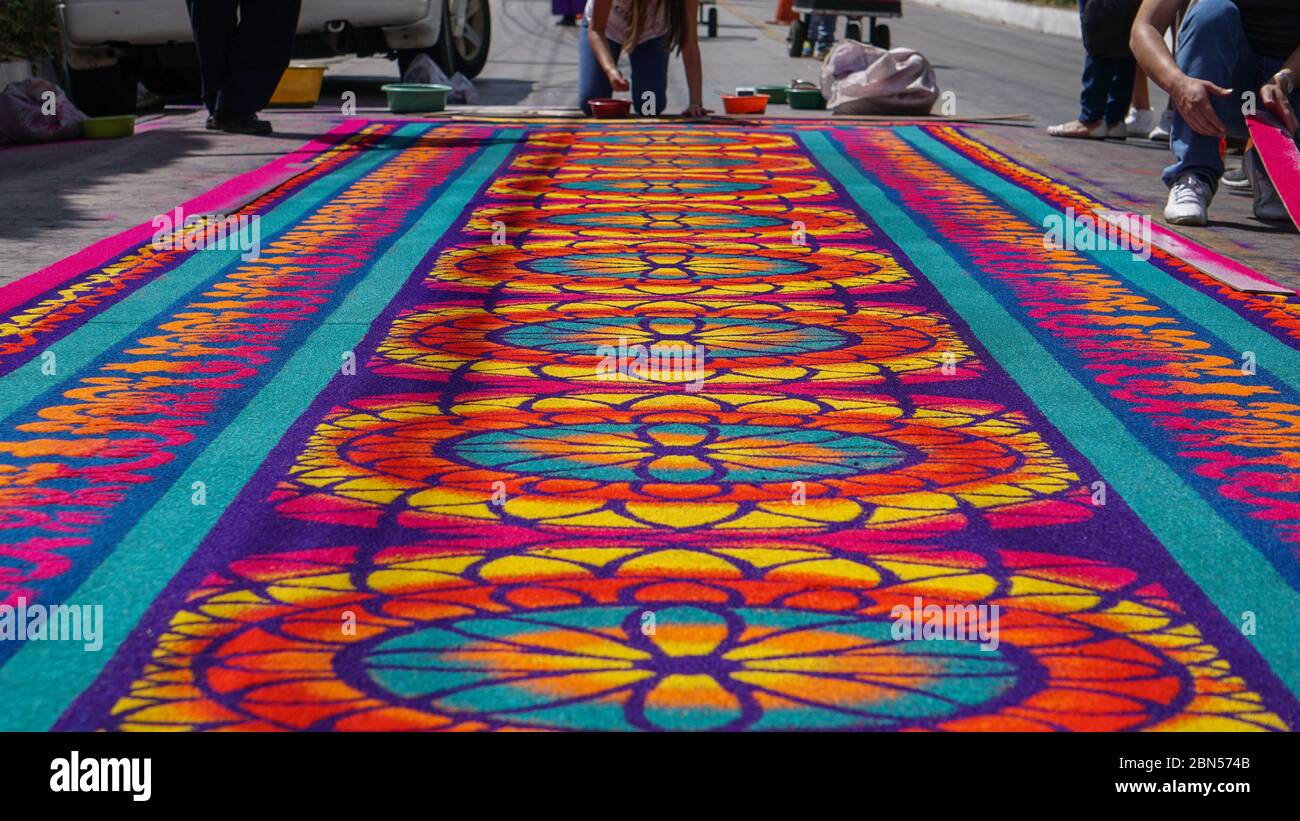 Un gruppo di persone che creano un tappeto colorato in Guatemala Foto Stock