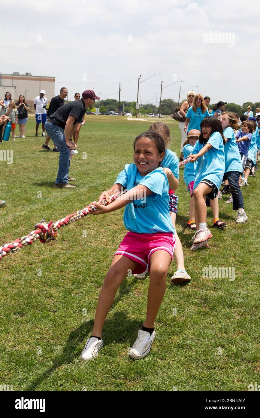 Austin Texas USA, maggio 10 2012: Gruppo di studenti delle scuole elementari di seconda classe multi-etniche partecipano al gioco di tiro di guerra mettendo due squadre che si tirano l'una contro l'altra su una corda lunga. ©Marjorie Kamys Cotera/Daemmrich Photography Foto Stock