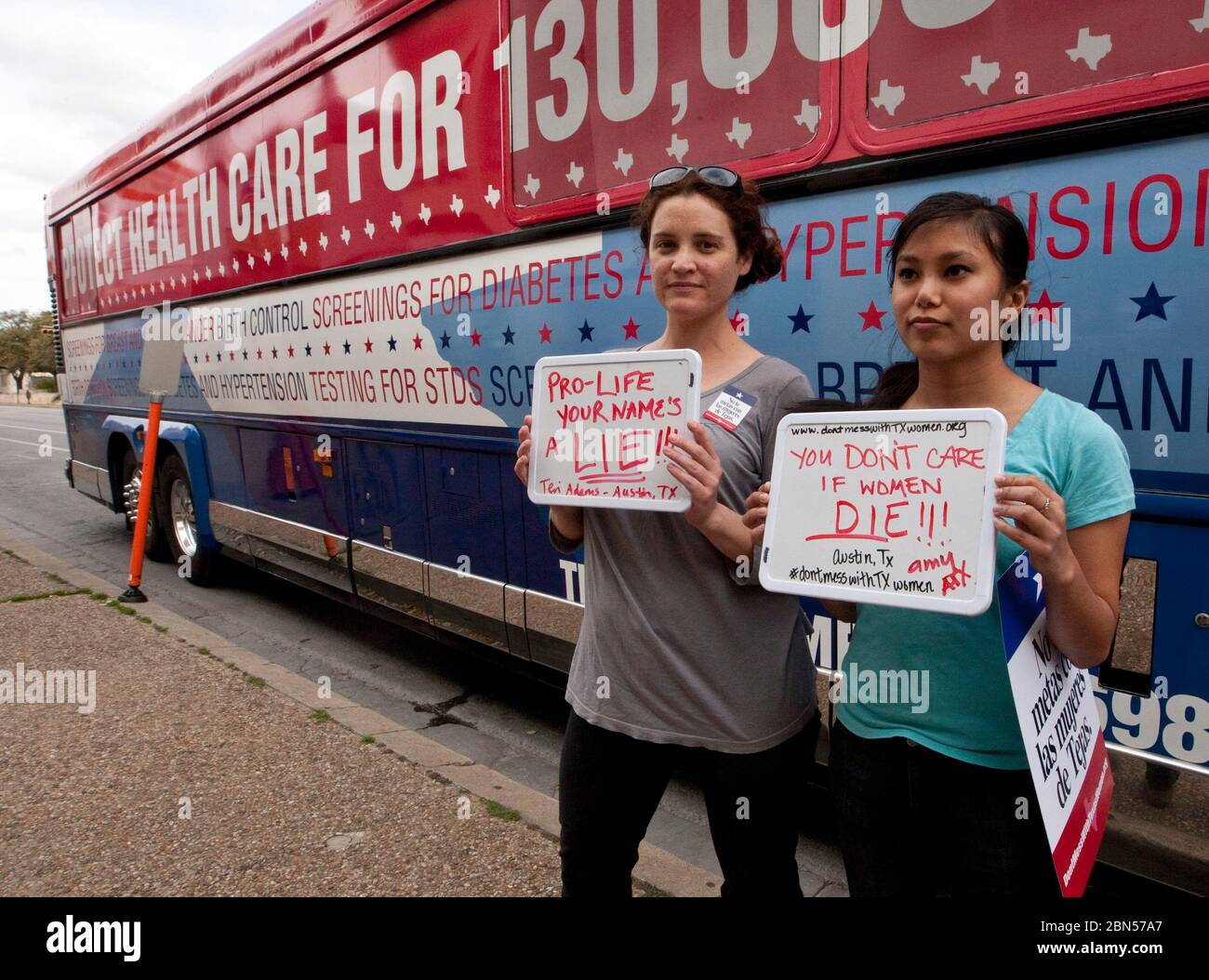 Austin Texas USA, marzo 13 2012: Due giovani donne hanno insegne pro-choice di fronte al Planned Parenthood's Don't Mess with Texas Women's Tour, che ha fatto una sosta vicino al campus dell'Università del Texas. L'organizzazione spera di aumentare la consapevolezza dei tagli ai programmi di salute delle donne che la colpa è su Texas Gov. Rick Perry. Le cliniche del Texas di Planned Parenthood perderanno i fondi il 14 marzo dal programma sanitario delle donne del Texas Medicaid, che serve circa 130.000 donne a basso reddito. ©Marjorie Kamys Cotera/Daemmrich Photography Foto Stock