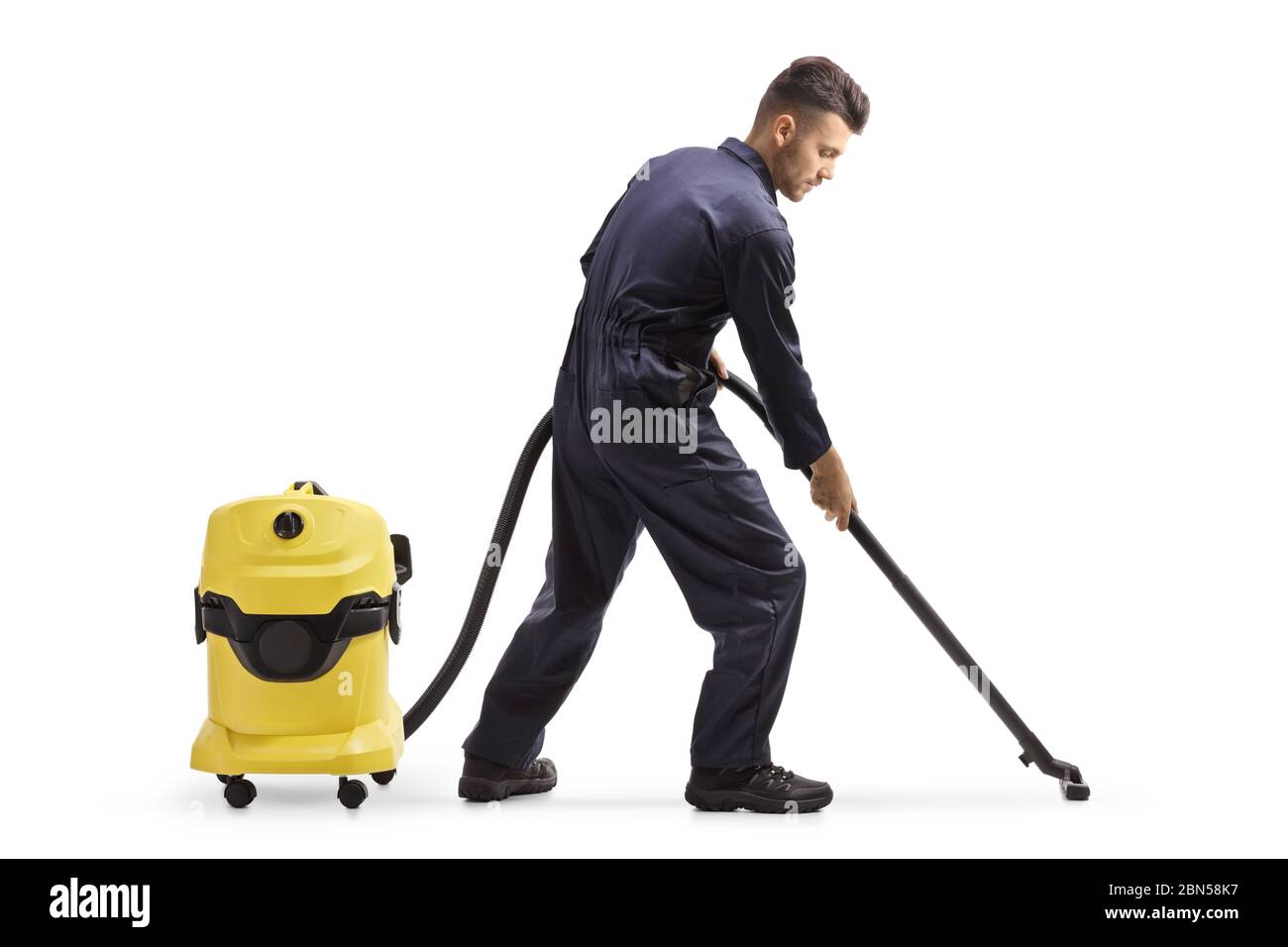 Scatto a tutta lunghezza di un janitor in un uniforme che pulisce il pavimento con un aspirapolvere isolato su sfondo bianco Foto Stock