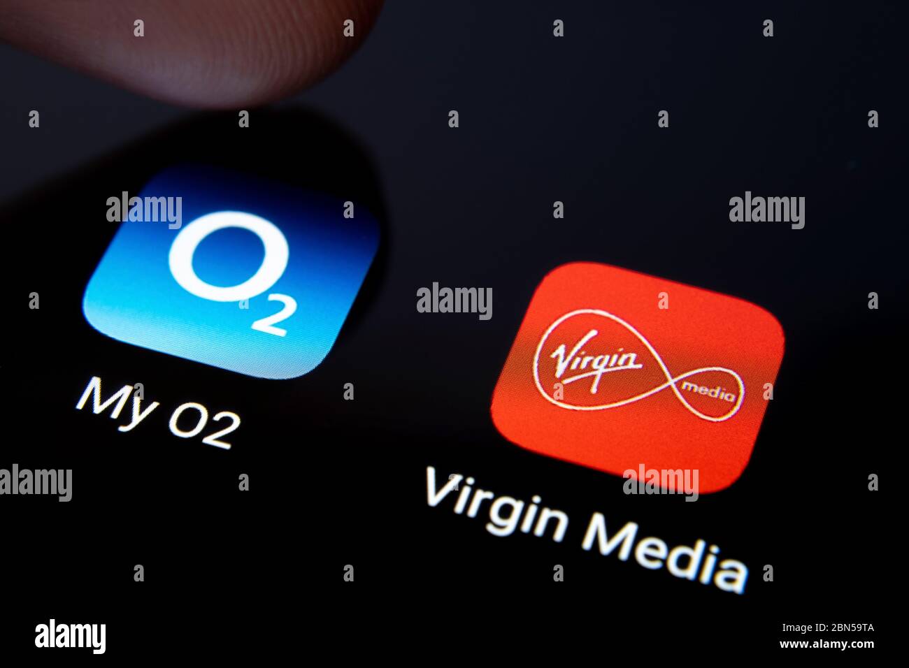 Stone / United Kingdom - Maggio 12 2020: Virgin Media e le applicazioni My O2 sullo schermo dello smartphone e premendo una delle due dita. Macro. Concetto di potenziale m Foto Stock