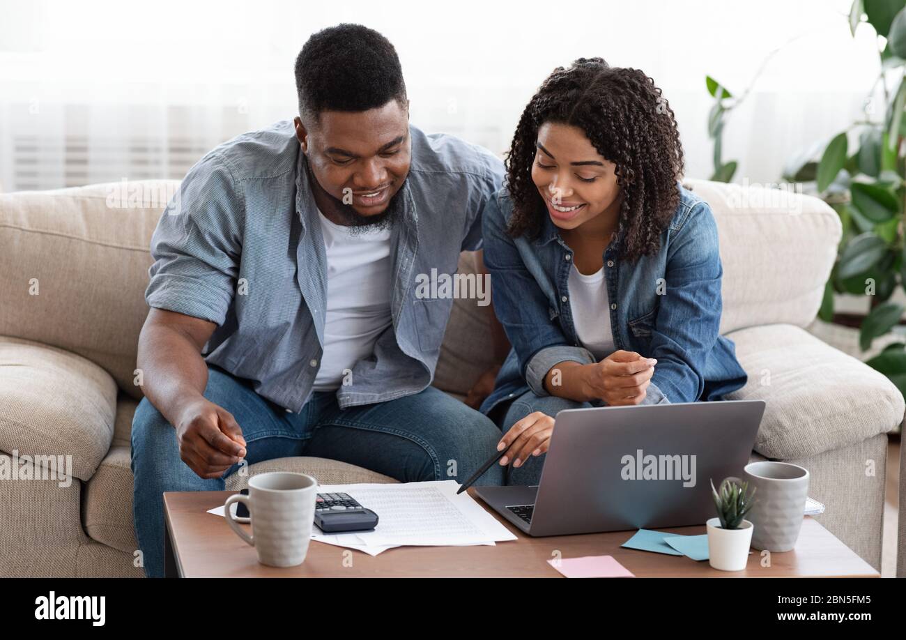 Giovani coniugi africani che gestiscono insieme il loro bilancio familiare in patria Foto Stock