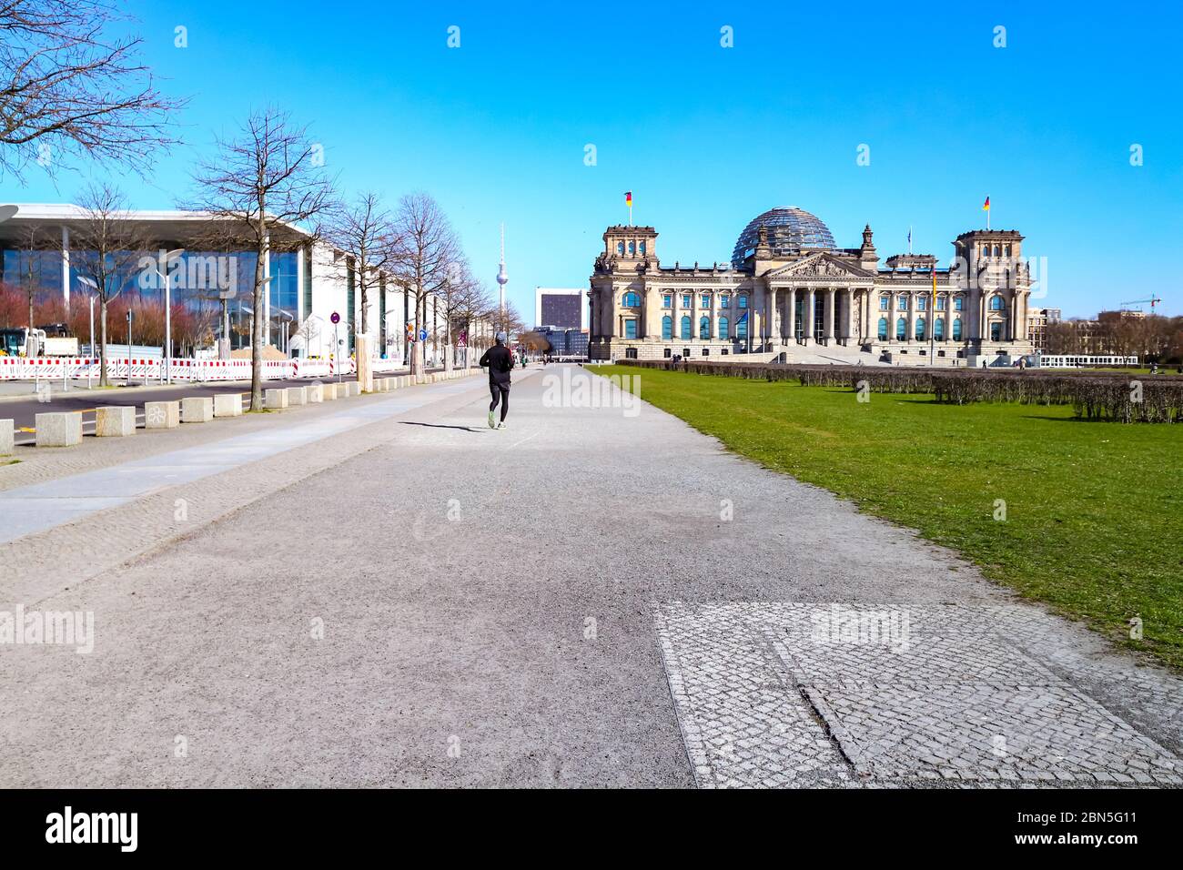 Lone Jogger presso l'edificio Reichstag durante la chiusura di Coronavirus in Germania. Foto Stock