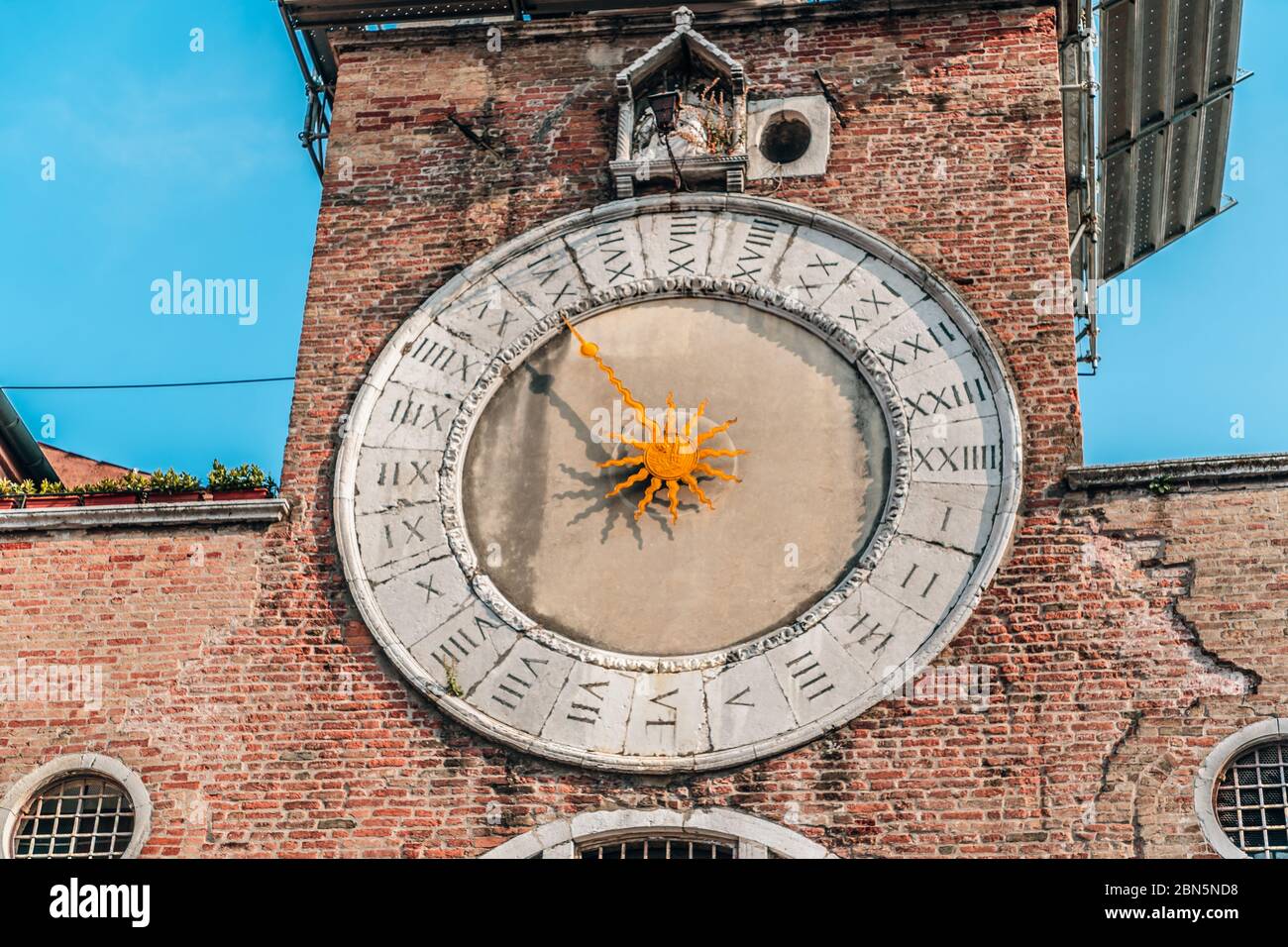 Una grande torre di mattoni con un orologio sul lato di un edificio. Foto di alta qualità Foto Stock