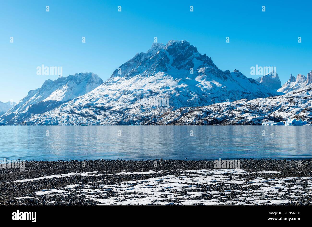 Vulcanica spiaggia di ciottoli neri lungo il Lago Gray (Lago Grigio) in inverno con la cima Paine Grande, Parco Nazionale Torres del Paine, Patagonia, Cile. Foto Stock
