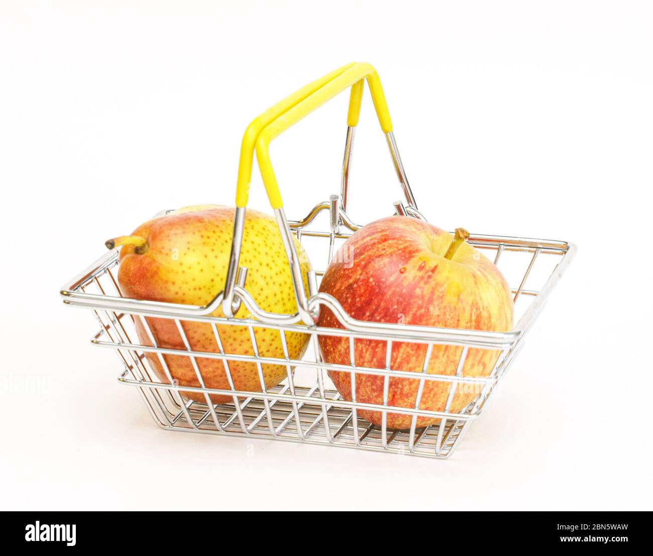 un piccolo cestino con frutta, mele, pere su sfondo bianco. Cibo sano, cibo vegetariano, verdure, shopping al supermercato. Foto Stock
