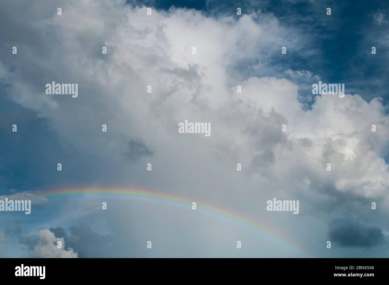Arcobaleno di cielo naturale con cielo blu e nuvole bianche e arcobaleno colorato nel cielo uso per sfondo Foto Stock