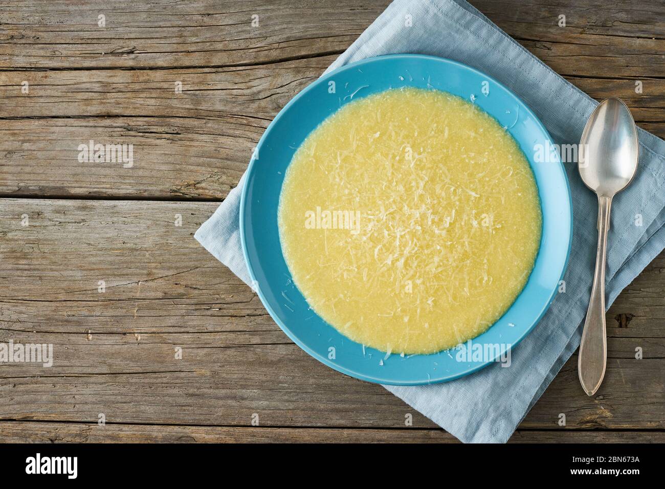Polenta, porridge con formaggio Parmigiano su vecchio sfondo di legno scuro Foto Stock