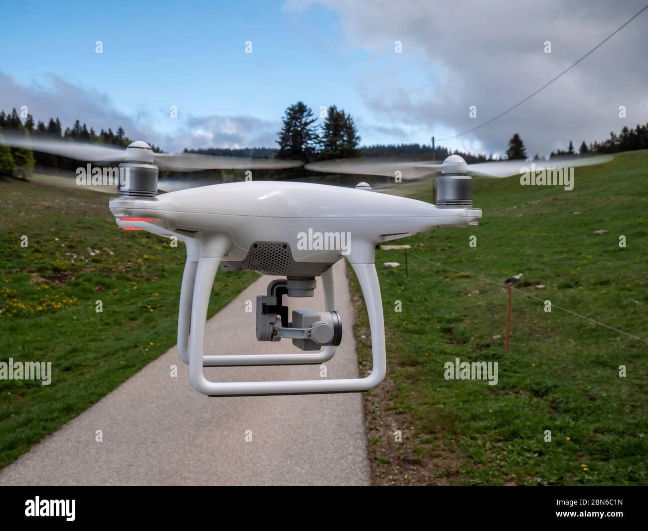 Un drone viene catturato con un passaggio fisso davanti alla telecamera. Il drone si trova in una zona boschiva in Svizzera. Foto Stock