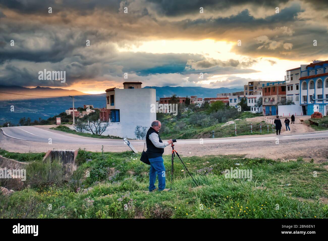 Chefchaouen, Marocco - 30 aprile 2018: L'uomo scatta foto di un tramonto spettacolare alla periferia di Chaouen Foto Stock